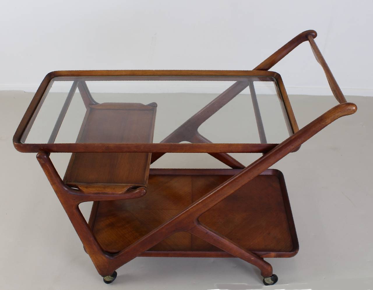 Beautiful Italian design tea trolley.
Designer; Cesare Lacca.
Manufacturer: Cassina, Italy.
Walnut wood with original glass and small tray.

Standard parcel shipment advised.