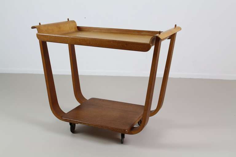 This early version of the Rolo serving trolley has a loose tray of plywood (birchwood) and a base of oak. 
The beautiful combination of a square base with elegant arms to hold the bentwood tray is stunning. 
Model: PE31 with an extraordinary