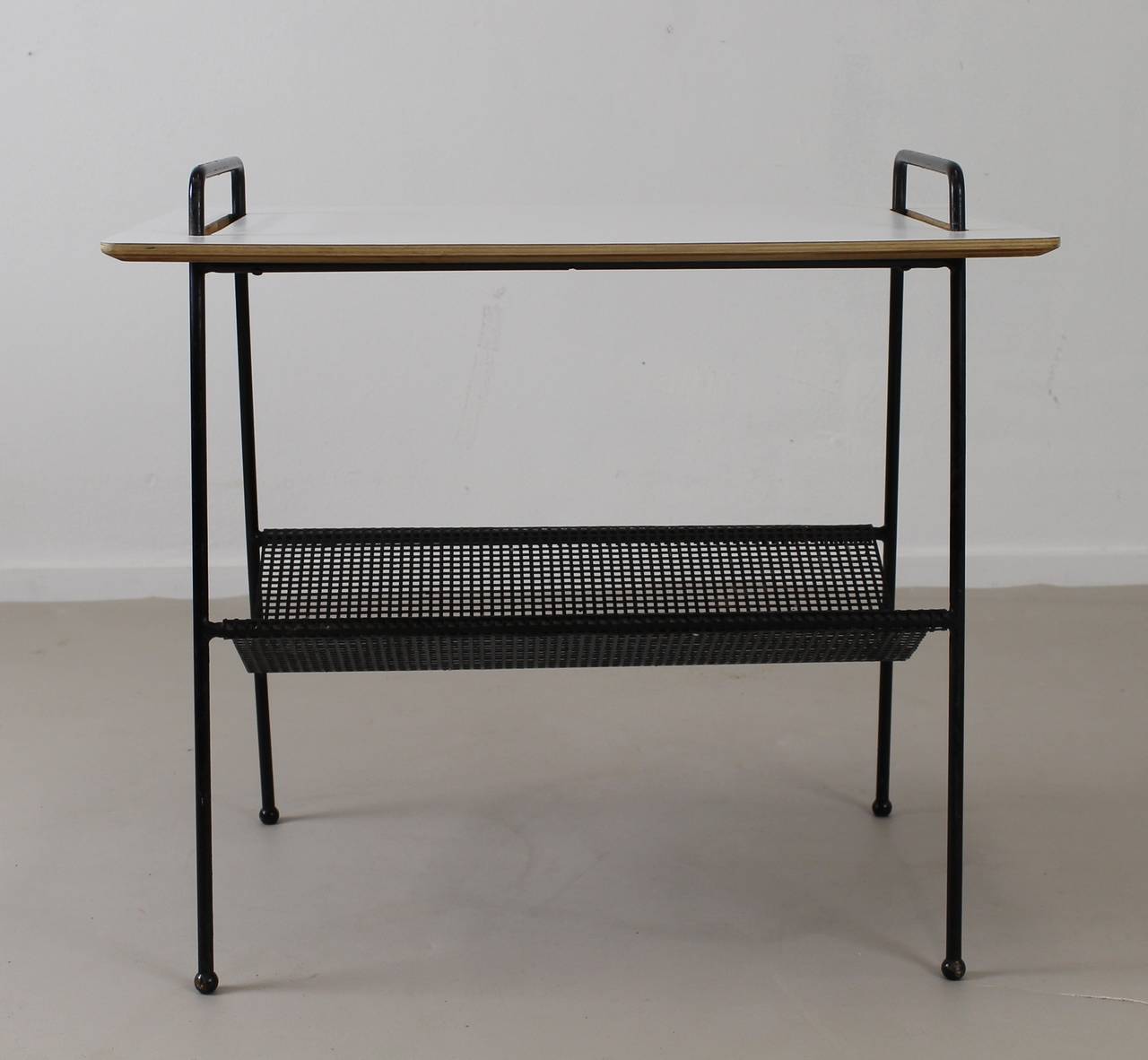 Scarce type of side table with presentation layer.
Black metal perforated magazine layer.
White laminated top.
Designer: Cees Braakman.
Model: TM 04.
Marked with Meubles Pastoe Bruxelles.

Express parcel shipment advised