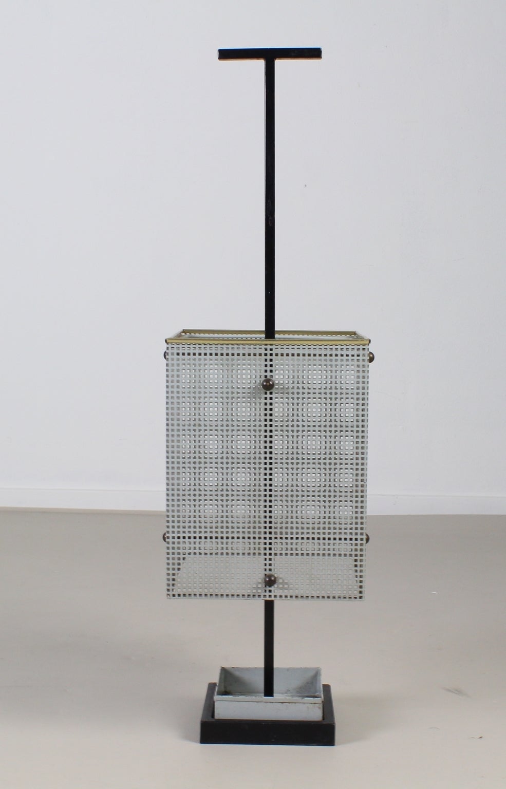 Nicely shaped umbrella stand.
Dutch design and manufacturing.
Wrought iron base with grey water reservoir.
Perforated metal bin with brass colored edge.
Nice decoration with brass ball screws.
Black metal handle.