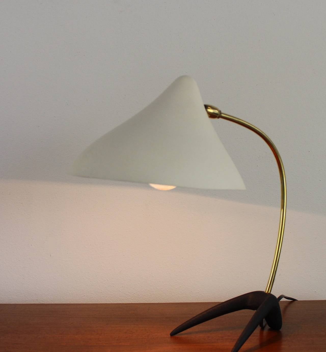 Famous elegant table lamp.
Designer: Louis Kalff.
Manufacturer: Philips The Netherlands.
Black metal feet and brass arm.
Broken white metal hood.
