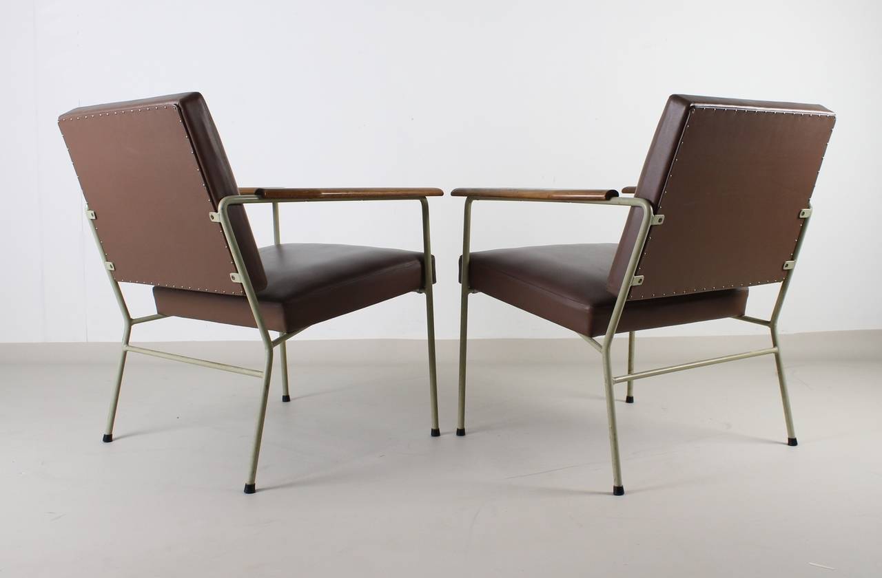 Elegant thin metal frame.
Original upholstery in artificial brown leather.
Beige painted frame.
Wooden armrests.
The design resembles the work of the Dutch designer Coen de Vries.

 