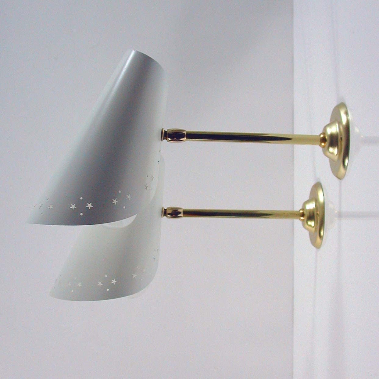Awesome Mid-Century wall lamps, made in Italy in the 1950s.
The lamps are made of brass and white lacquered metal. The shades are adjustable.

They require a E14 screw on bulb each and work on 110V as well as 220V.