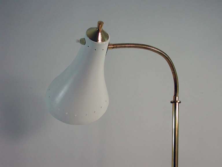 Awesome floor lamp with flexible gooseneck lamp arm ans snow white lamp shade on brass base, made in Italy in the 1950s.
The lamp requires a standard E14 Edison screw on bulb and works on 110V as well as 220V. It has got a European Continental