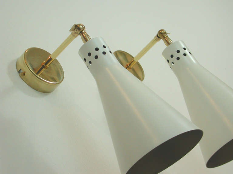 Awesome Mid Century wall lamps, made in Italy in the 1950s.
The lamps are made of white lacquered metal with bronze lacquering inside the shades. The shades are adjustable.

The lamps have got E27 Edison porcelain screw on sockets and work on