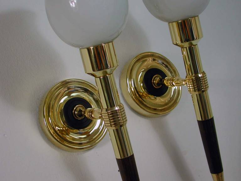 Awesome pair of 1950s French torchiere sconces. Made of brass and teak with white opal glass sconces.
The lamps have got French B22 bayonett sockets and work on 220V as well as 110V.

The sconces have been rewired and are in excellent vintage