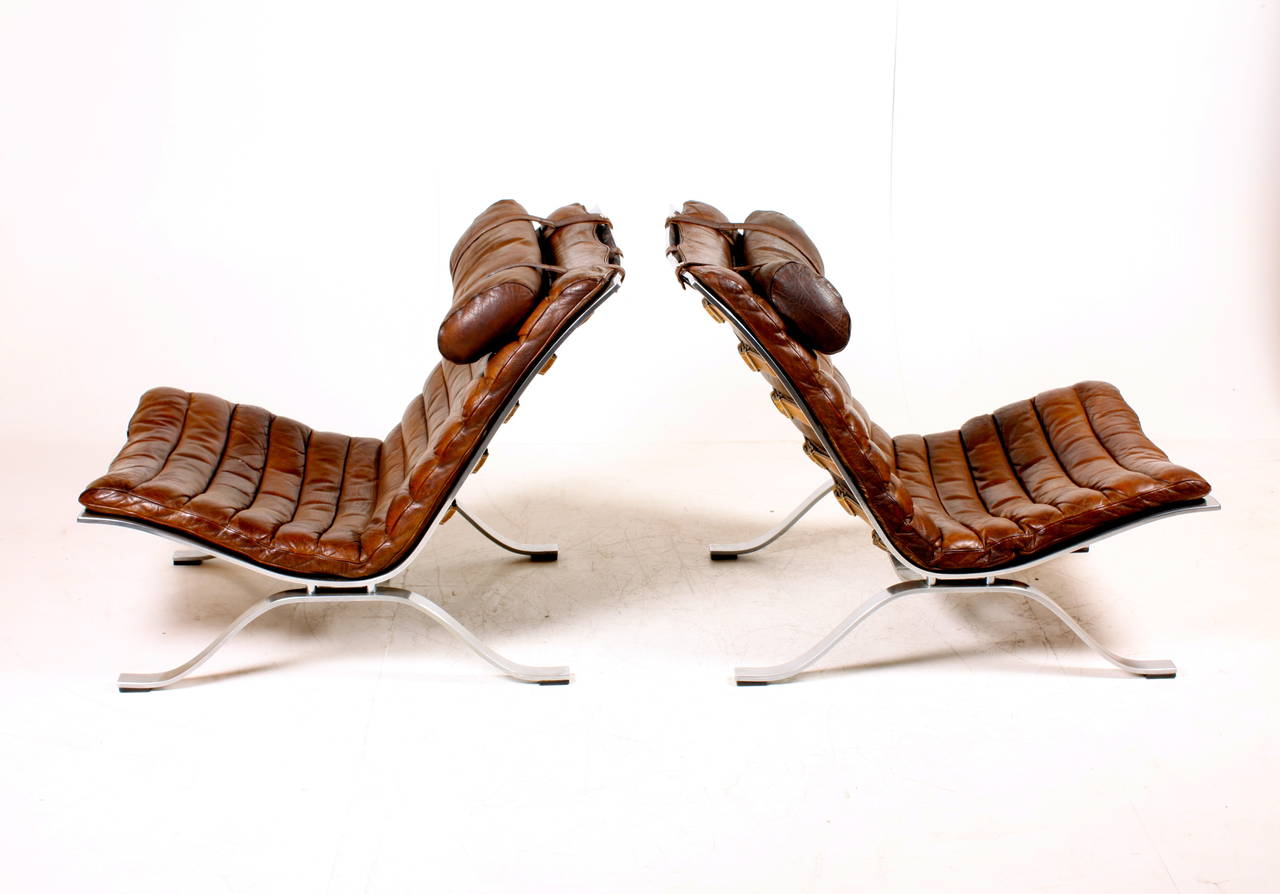 Pair of ARI lounge chairs in patinated leather and chromed steel. Designed by Arne Norell and made in Sweden in the 1960s. Great original condition.