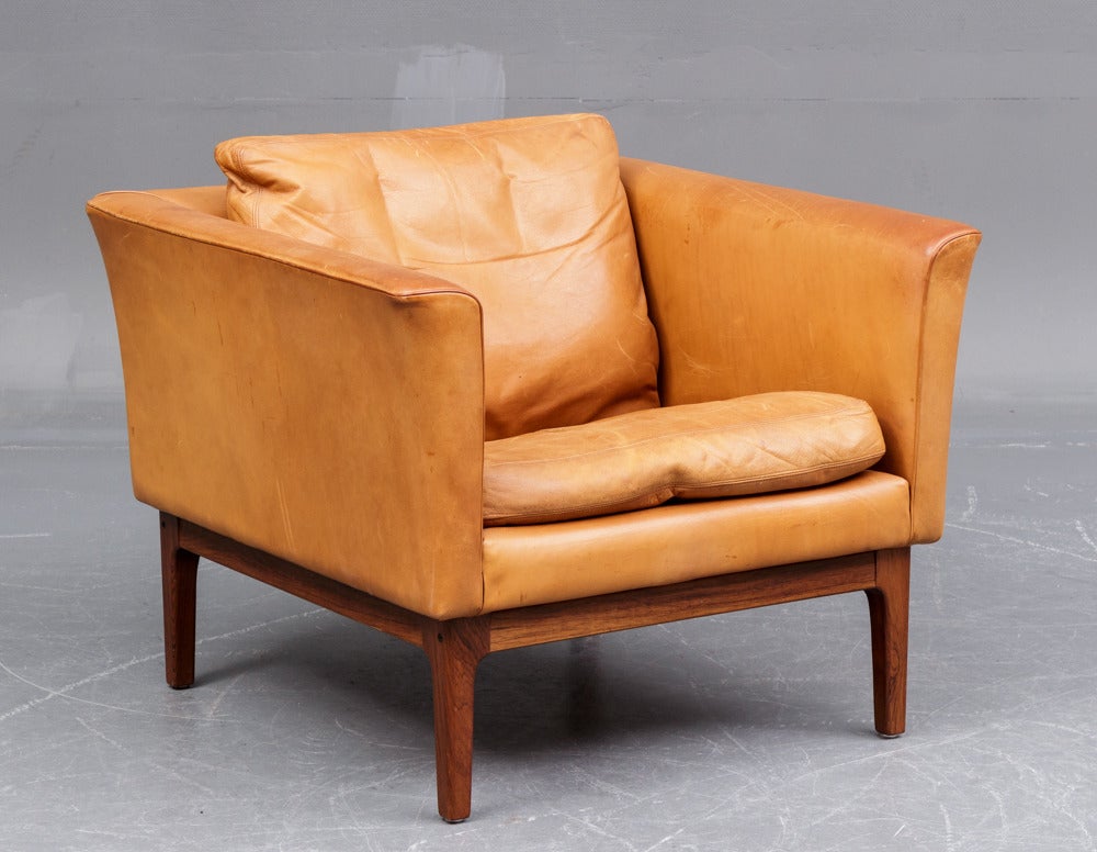 Beautifully patinated easy chair in natural leather on a rosewood base. Made in Denmark in the 1960's. Original condition.