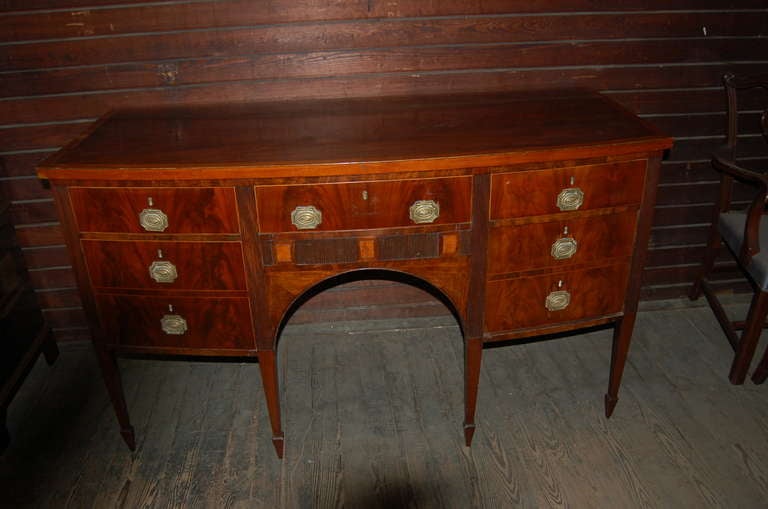 English mahogany sideboard, circa 1810. Beautiful bow front with a satinwood banding around the top with ebony string inlays. There are satinwood Inlays around the outer edge of all the drawers. There are three satinwood inlayed squares to the