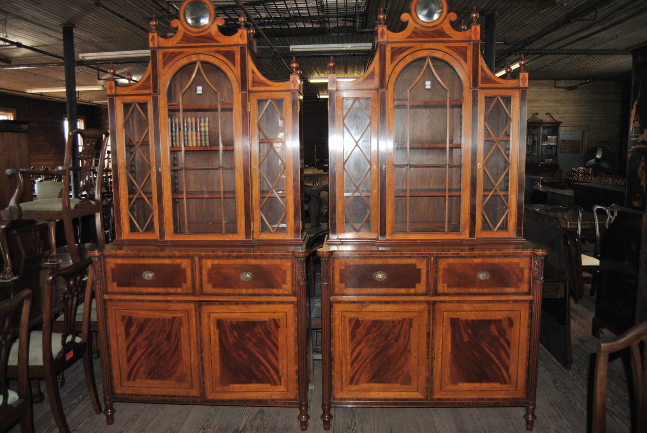This is a matched pair of Regency style bookcase or secretary made in England, circa 1940. These are a fantastic example of English bench made furniture at it's finest. Each cabinet is made of satinwood with rosewood banding, mahogany inlays and