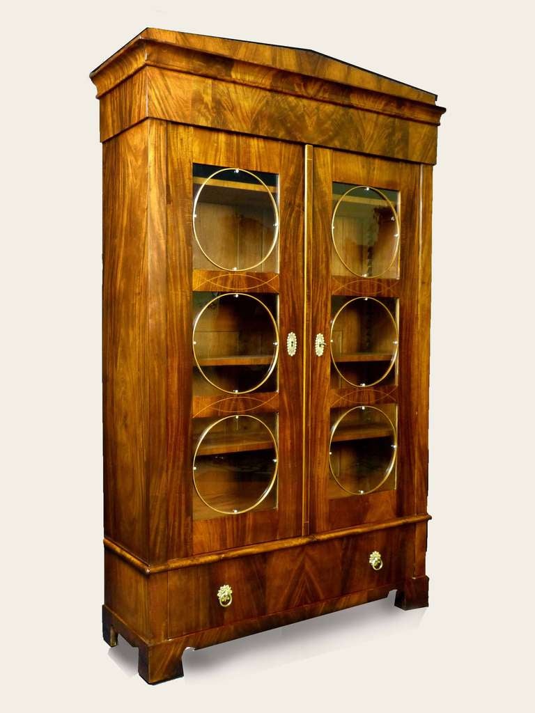 Fine Biedermeier bookcase of Vienese origin and of unique design. The exterior with the finest Cuban mahogany forming precious figures of feathers, crotch and cathedrals, not only at the front but also on the sides, on the Schinkel pediment as well