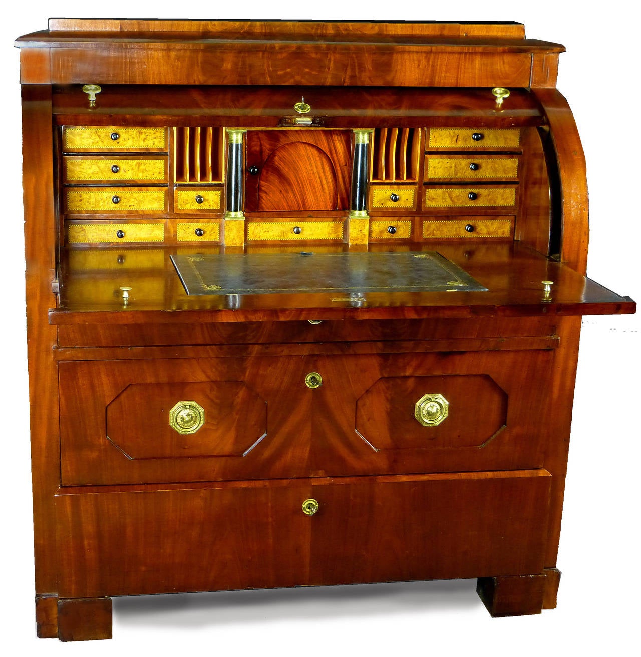Imposing Biedermeier bureau of flame mahogany and of North German origin with cylinder top. The sliding writing surface has a central tooled leather panel that rises to act as a lectern. Various small drawers above with bird's eye maple fronts