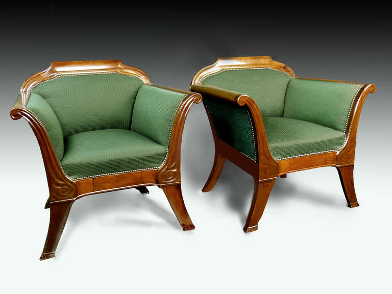 Fine and rare pair of walnut Art Nouveau design armchairs of tapered form with rolled arms and outsplayed front and rear legs adorned with subtle carved forms. The walnut and finish in great condition as well as the upholstery. Very comfortable.