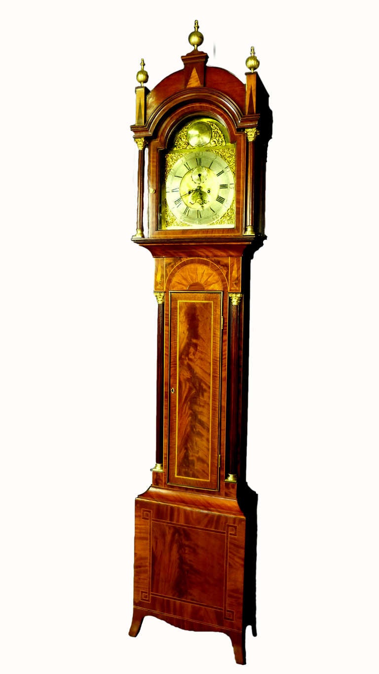 An Engish George III period inlaid mahogany longcase clock by George Clapham Brigg, Lincolnshire(UK). The brass arched dial with Roman numerals and subsidiary dials of minutes and calendar.The silvered circle at the upper part of the brass dial