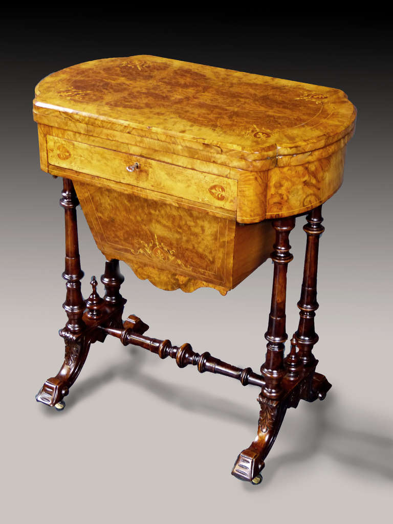 Attractive and smart Victorian sewing/work table, the upper body veneered entirely with burr walnut and thuya and inlaid with delicate marquetry designs, over finely turned twin supports terminating on carved brackets joined by a turned stretcher,