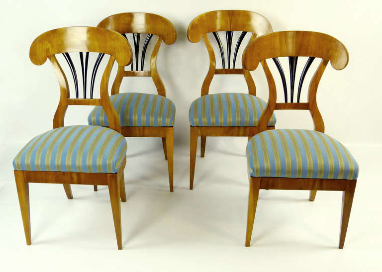 Exquisite set of 4 light colored cherry chairs of the first Biedermeier period and of southcentral German origin, dating to the first quarter of the 19th century. The arched back-splats characteristic of this style with ebonized fan design below and