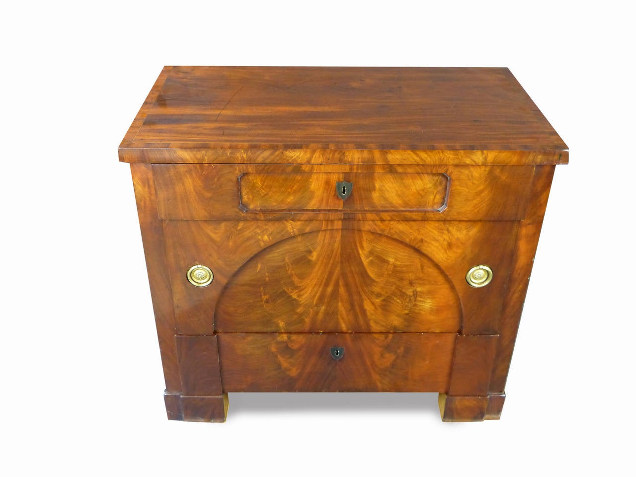 Exquisite small Biedermeier commode of Austrian origin with attractive figured mahogany on all four sides and banding on the upper surface, three graduated drawers the middle one being quite large with recessed ring pulls, the front with the