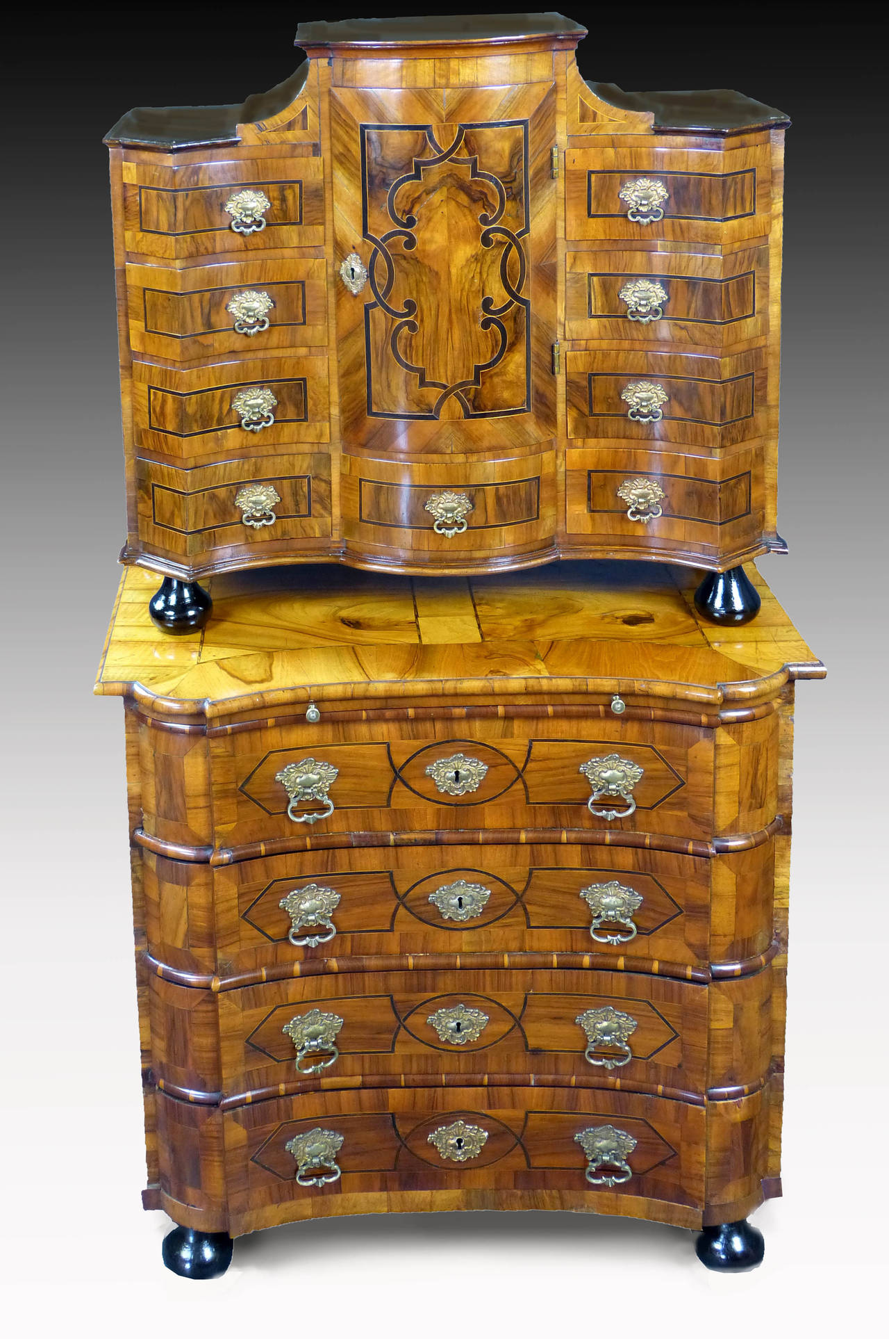 Outstanding mid-18th century Baroque South German figured walnut cabinet on chest, the superstructure with curved central door over single drawer, flanked by eight drawers, all with secret locking mechanism, over matched concave base with brushing