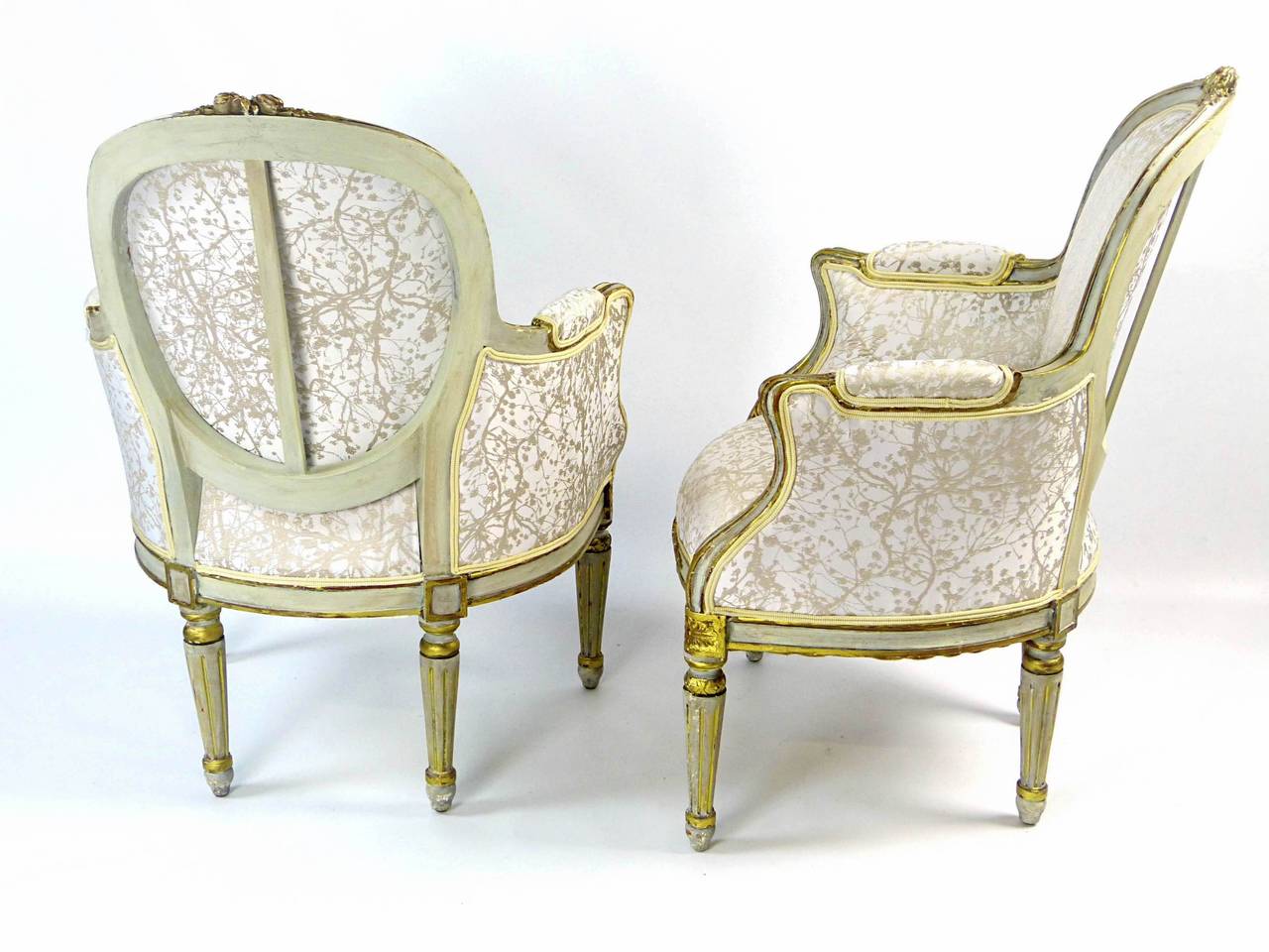 Attractive Louis XVI style bergeres dating to the last quarter of the 19th century with arched backs, serpentine fronts and with discreet carvings throughout, supported by turned and reeded tapering legs. The underlying wood is beechwood painted