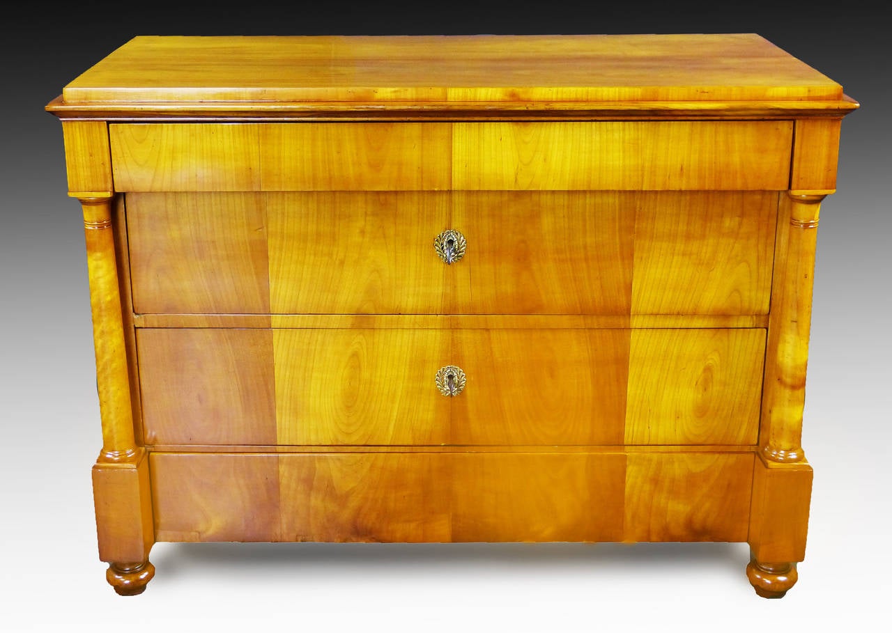 Swedish cherrywood Biedermeier commode dating to the first third of 19th century. It has four drawers of varying size flanked by two reverse tapering Doric columns with discreet ring type tops and bottoms. The size and placement of the drawers are