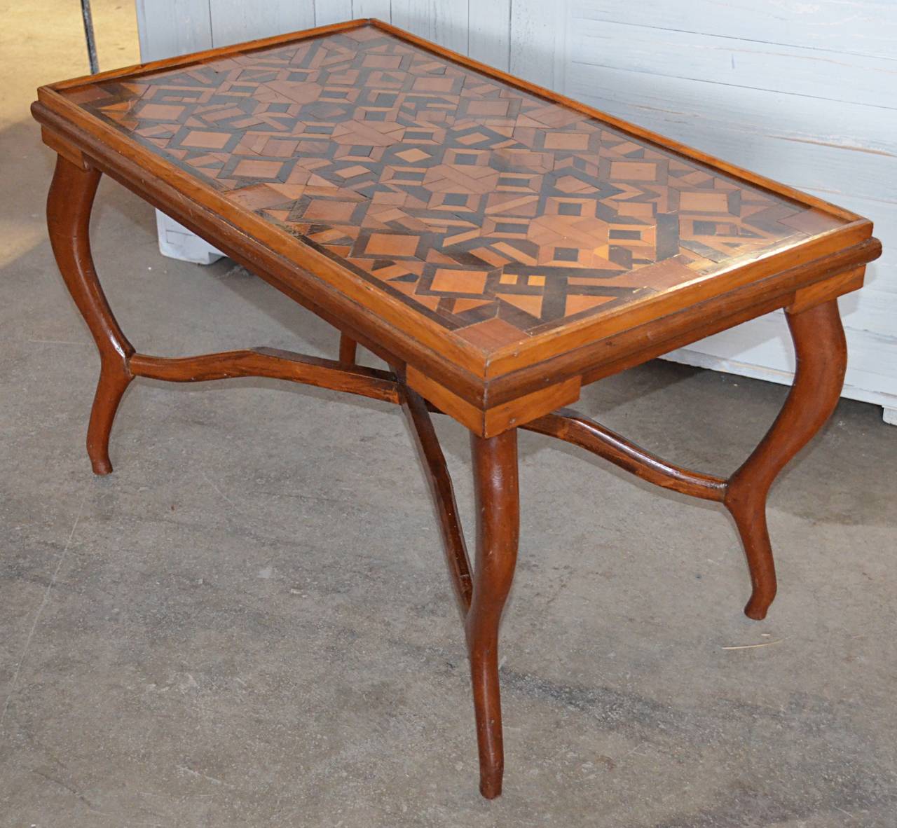 Charming mixed woods parquetry top table with uniquely shaped legs and stretchers, late 19th century-early 20th century.