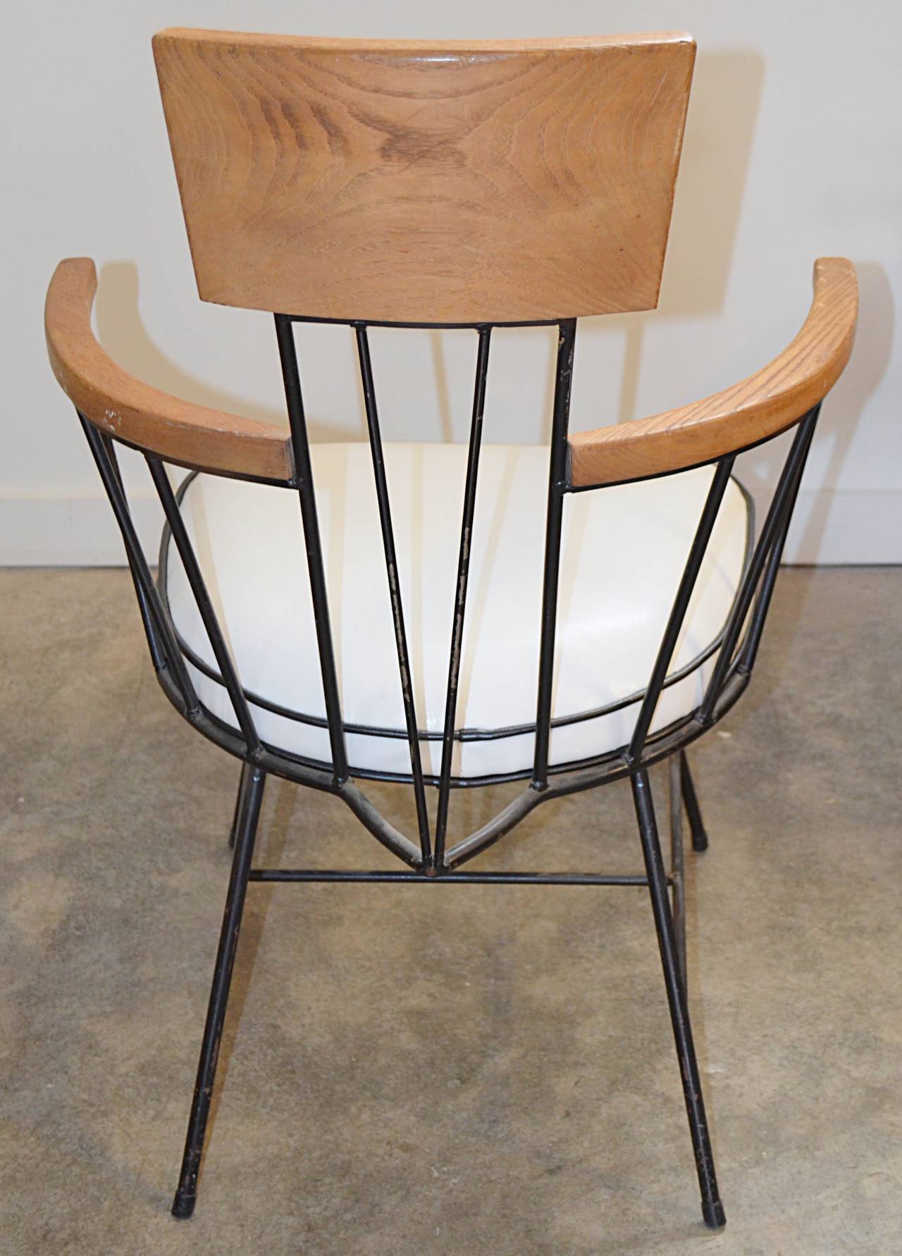Nice set of Iron chairs with ash arm and back rests. New contrast vinyl cushions. All missing original feet but have rubber tips. Often attributed to Paul McCobb.