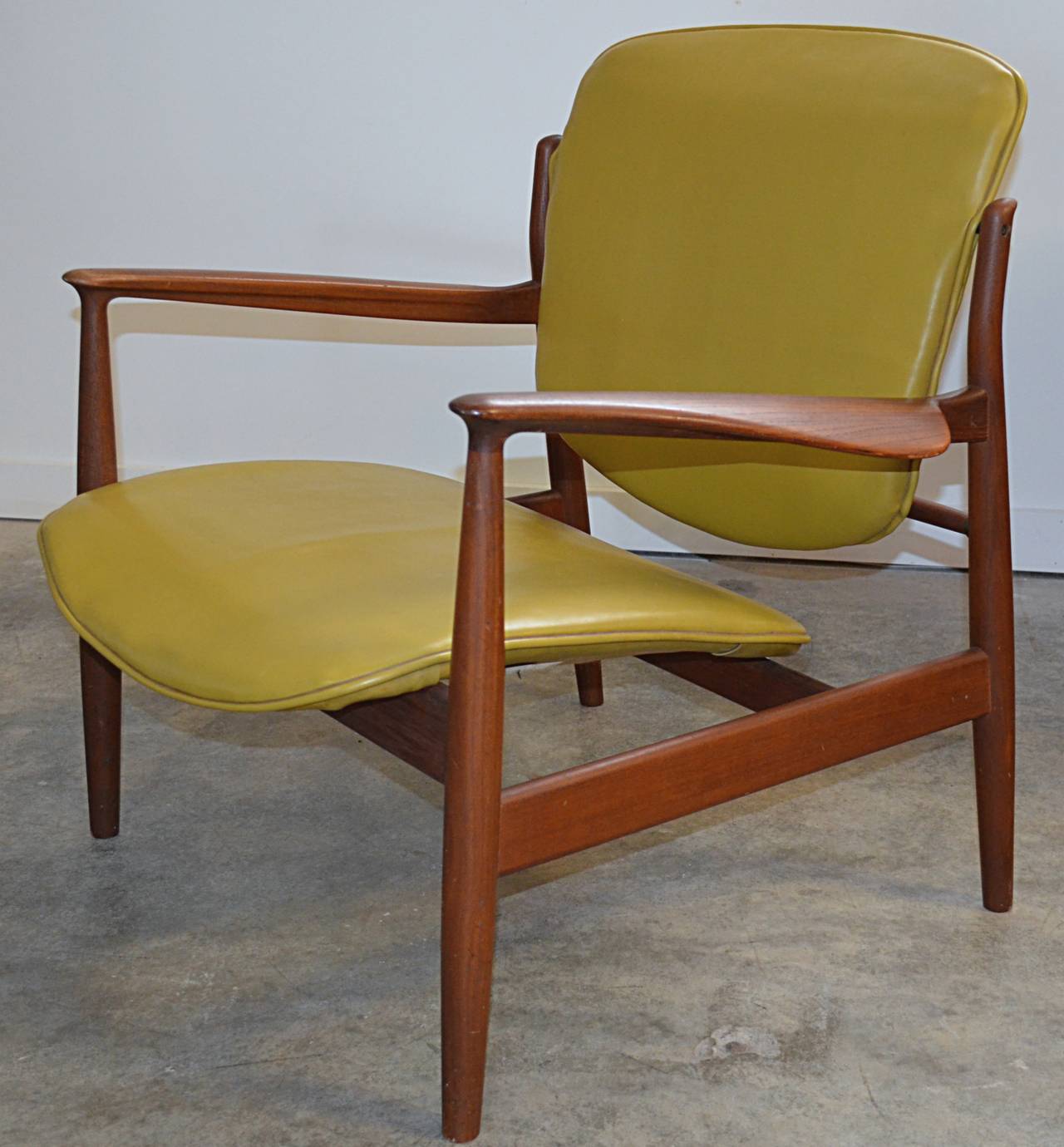 Classic Finn Juhl for France & Sons chair executed in teak. Retains original mustard vinyl covering. inquire about a second chair.