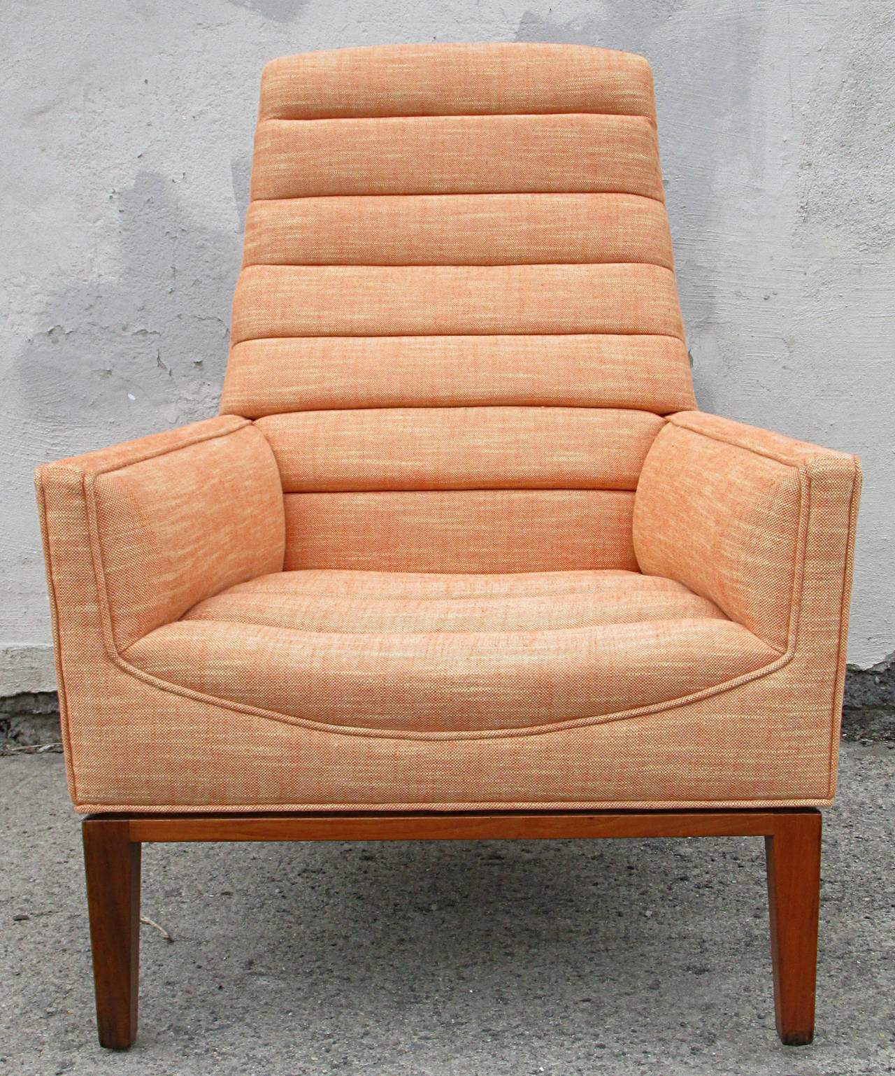 An elegant high back lounge chair by Edward Wormley for Dunbar. Newly upholstered in a linen strie. Walnut base.