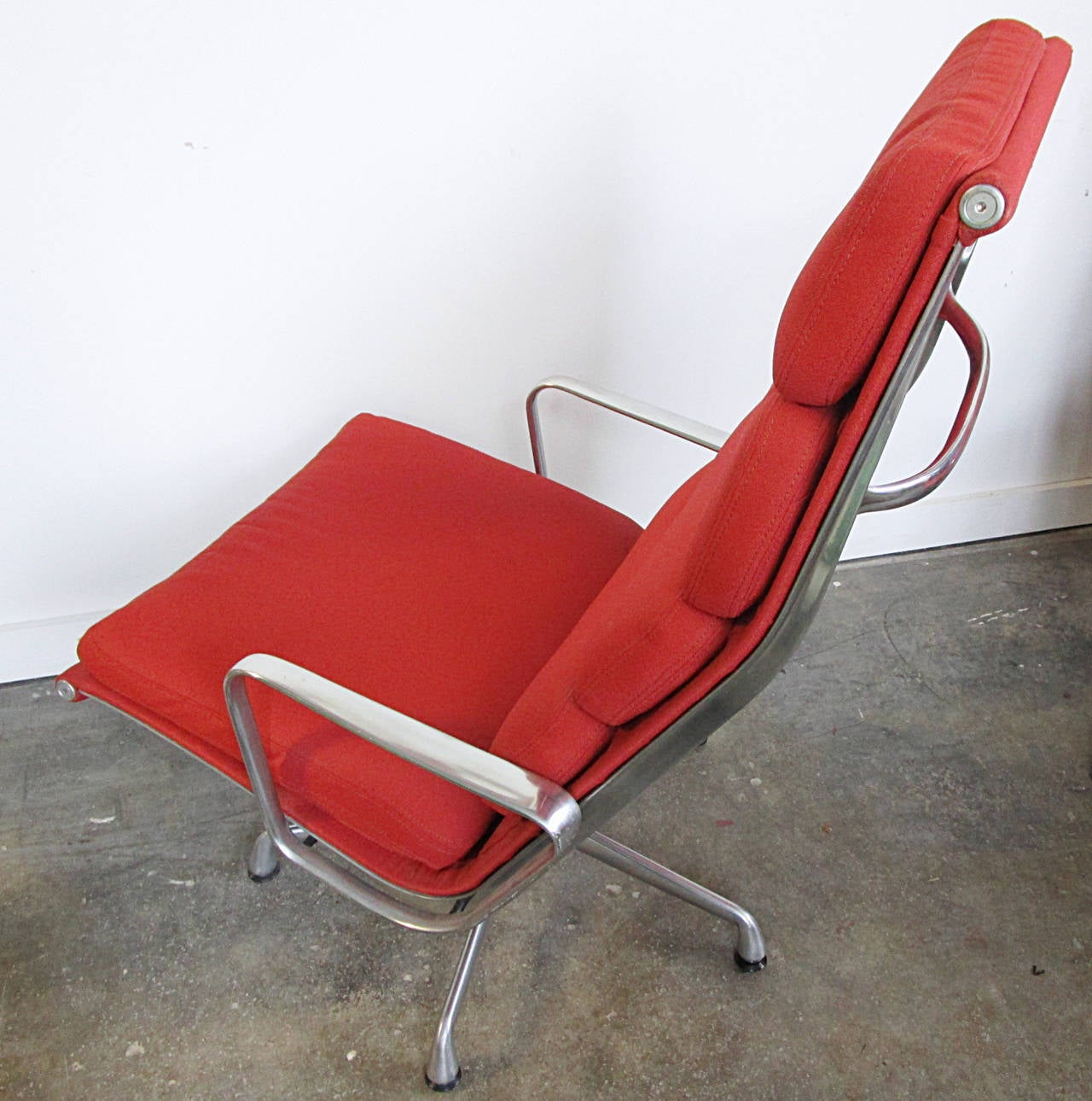 Classic Eames executive soft pad tilt swivel lounge chair for Herman Miller. Originally design in 1958 as part of the aluminum group. This chair hails from the late 1980s. High back four pad design in a ripe tomato fabric.