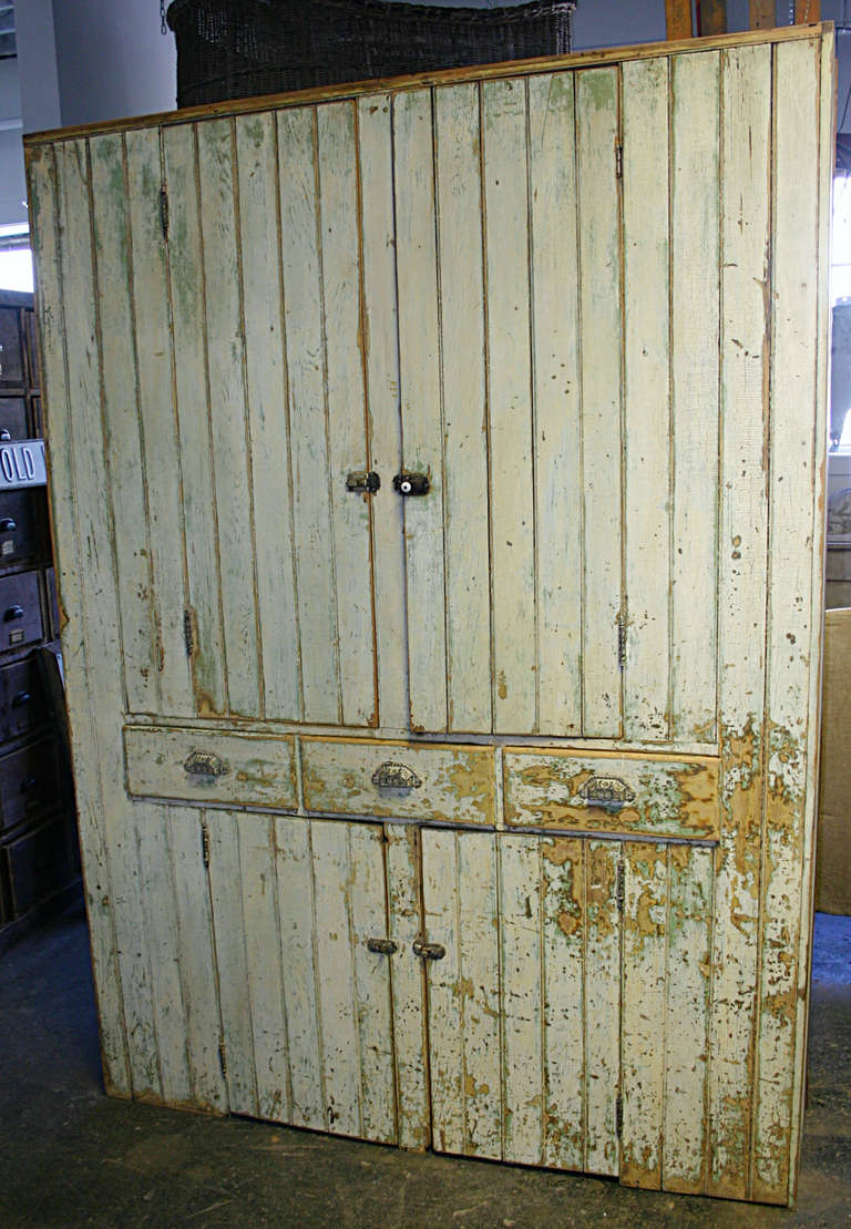 Large scale farm cupboard from upstate New York, Catskill region. Retains original layers of paint outside and in. Exterior is a creamy white with yellowing hues over and apple green interior is more white over a cornflower blue. Two door over three