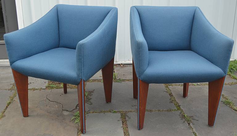 An interesting pair of cube form chairs with walnut legs. The legs are reminiscent of Ponti with the triangular off-set taper. Nice proportions all around and unusual trim detail with welt continuing down each leg accenting the off-set leg.