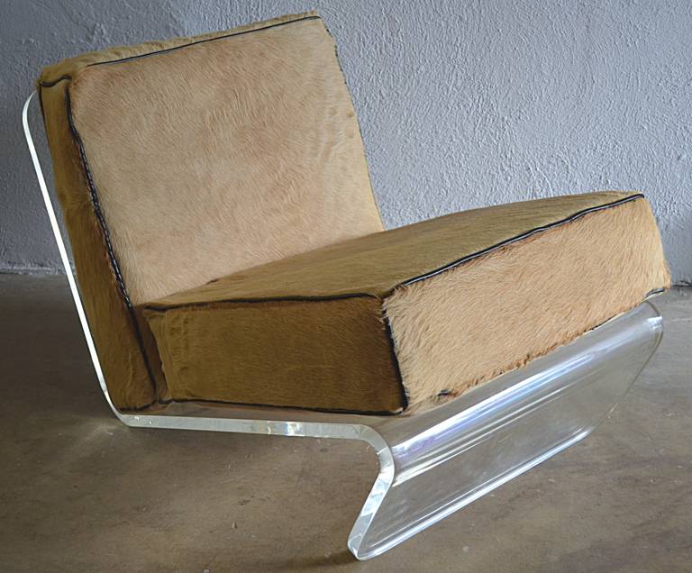 Great pair of bent lucite lounge chairs with original buff colored cow hide and contrasting black leather welt box cushions. Lucite is 3/4