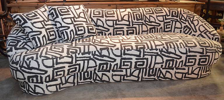A biomorphic, cloud, style sofa by Directional. Possibly Kagan. a black and white graphic fabric reminiscent of Keith Haring covers this curvaceous form recessed plinth base to serpentine top line.