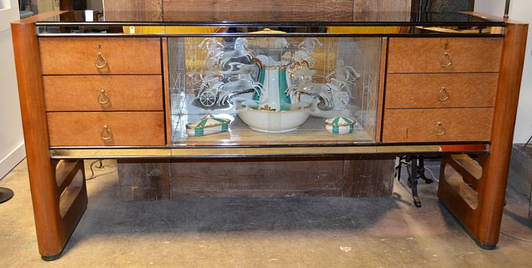 A classic Italian late deco, early mid century case piece. This beauty has all the bells and whistles from burled wood drawer and cabinet fronts to Roman scene etched glass door panels. Black glass top is framed by two end supports with bull nosed