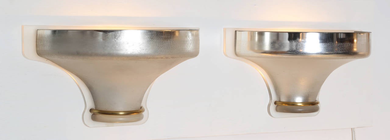 Pair of lovely Venetian glass wall sconces in mirrored antiqued glass, brass and illuminated frosted Lucite by Karl Springer, circa 1980s. Each sconce holds one standard-base light bulb; hard-wired installation. Each with an etched signature to