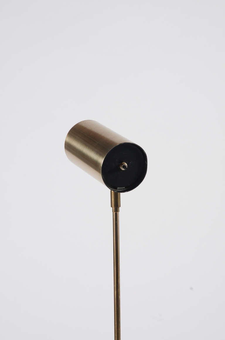 Minimal brass floor lamp with a spotlight head and marble base by Robert Sonneman.