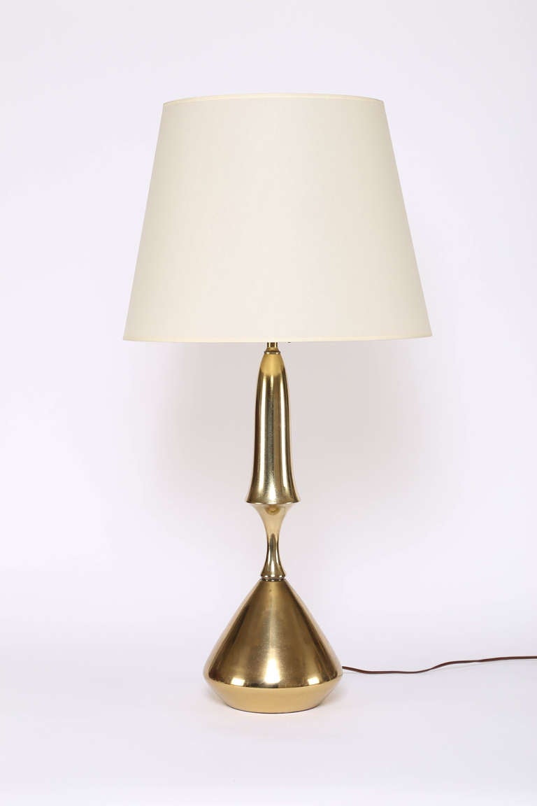 Lovely sculptural 1970s brass table lamps with new parchment shades. The three-way switch illuminates a single bulb, two bulbs or all three. 35-1/2" H x 18" D, base 8" in diameter, lamp body 24" H to sockets. 

These lamps are