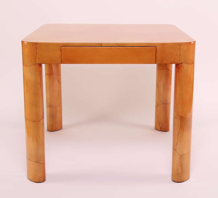 Beautiful dyed-parchment games table by Karl Springer. The graciously curved top corners seamlessly conform to oval legs. The table is nicely sized for use as a breakfast table. Features a single drawer.