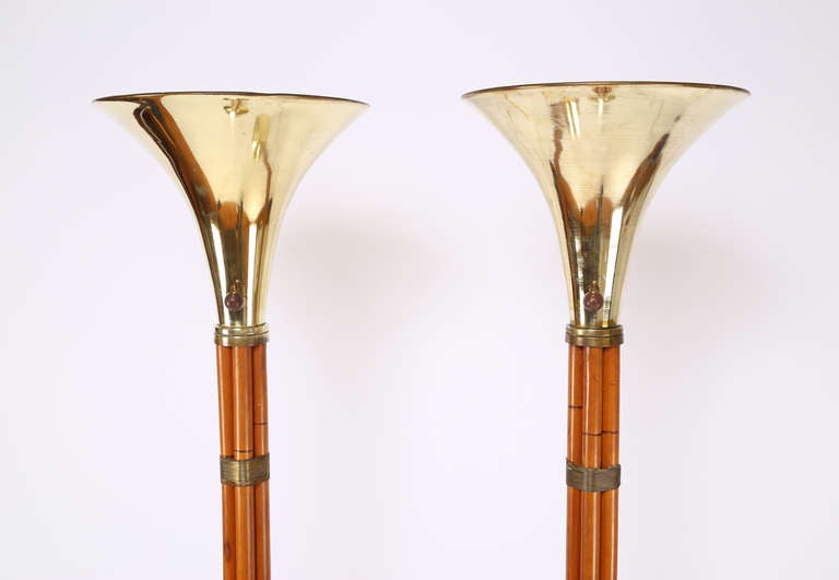 Pair of 1950s brass and faux-bamboo Russel Wright for Raymor torchiere floor lamps. Five maple rods faux finished to look like bamboo are wrapped with solid brass wire. The bases and tops are solid spun brass. Original wooden ball knobs on three-way