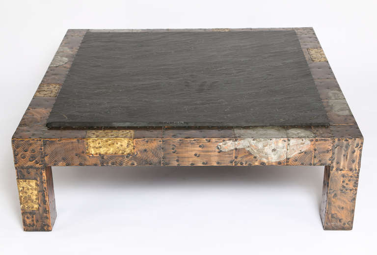 Brutalist patchwork coffee table by Paul Evans for Directional, circa 1970, is clad in nailed-on panels of patinated copper, brass and pewter with an inset top of thick, natural cleft slate. Excellent original condition. 

