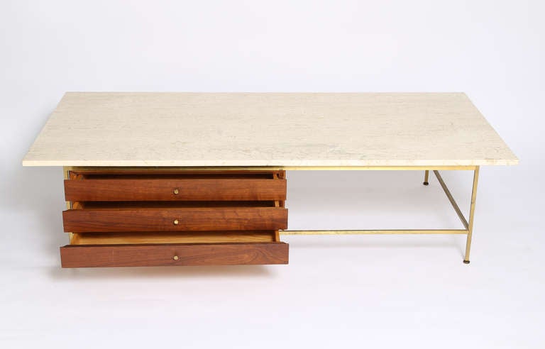 Large, sleek Paul McCobb for Calvin travertine-top coffee table.  Brass legs with three walnut drawers off-set to left. Signed in drawer. Original brass pulls.