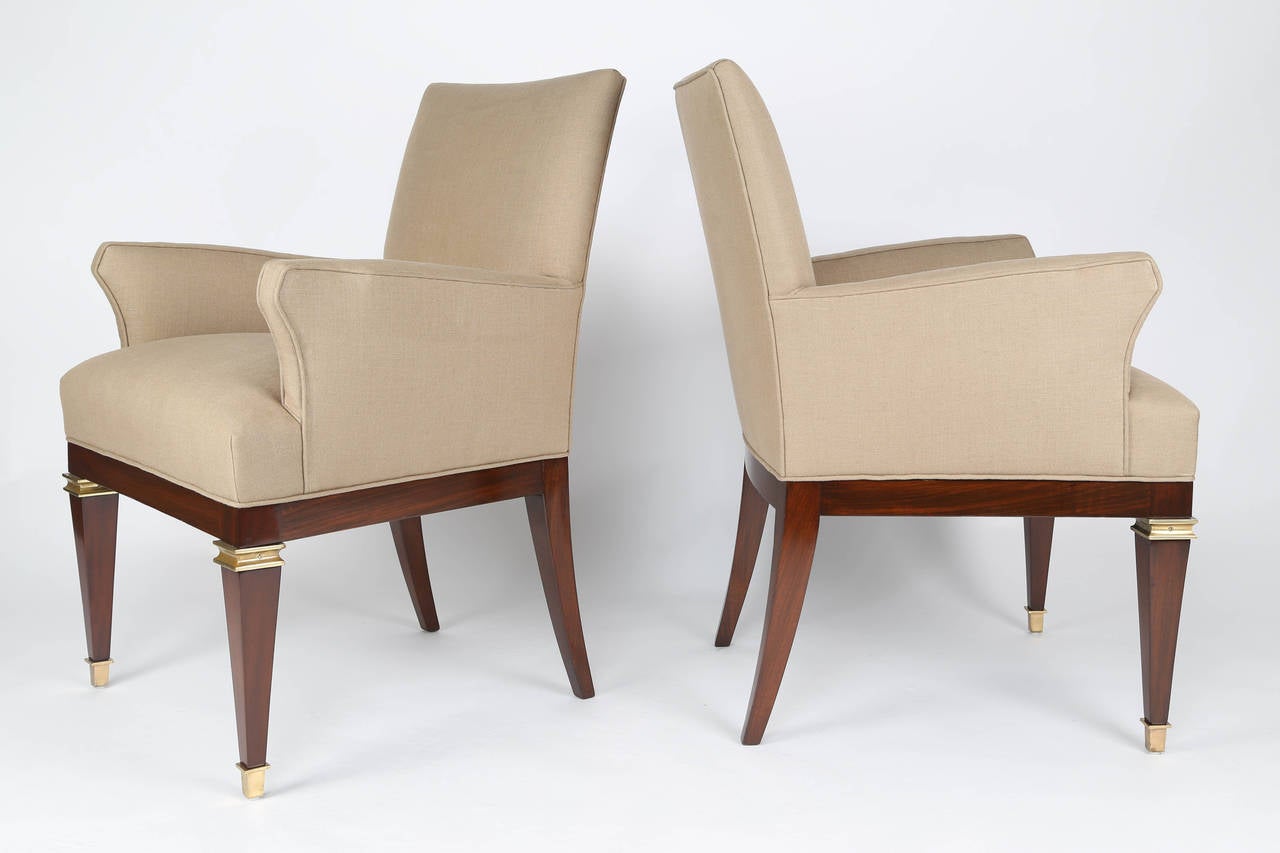 These stylish 1950s armchairs feature tapered square legs with brass-capped feet with additional brass banding on the upper front legs, and upholstered seats, backs and arms. Freshly refinished and reupholstered in beige linen. Arturo Pani, a