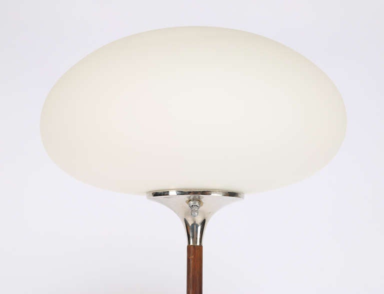 Classic 1960s Laurel floor lamp. A frosted glass mushroom shade rests on a slender, polished-nickel neck attaching to a walnut stem that connects to a flared, polished-nickel base. Measures: 56" height x 13" in diameter; base 10" in