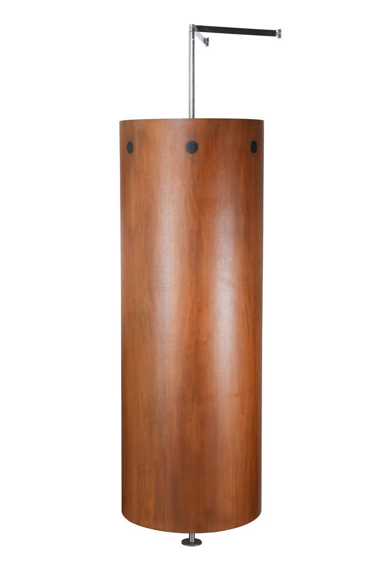 Zylindrischer Kleiderschrank aus Nussbaumholz aus den 1960er Jahren, drehbar von der Halterung bis zum Boden, mit einem Wandanschluss aus Metall. Im Inneren befinden sich ein Regal und eine Hängestange. Maße: 24