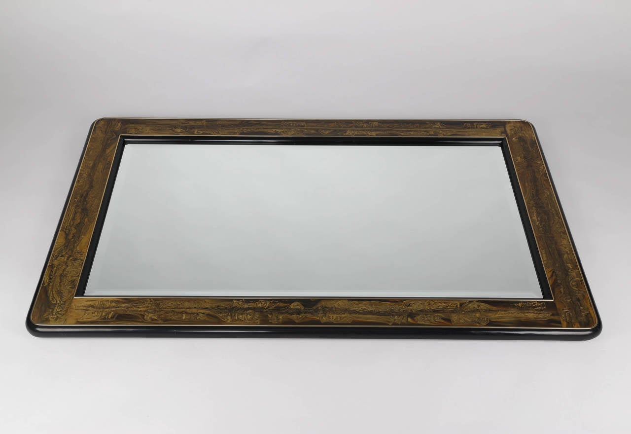 Stunning, large 1970s mirror with a rounded black-lacquer frame with polished-brass trim and inset etched-bass panels by artist Bernhard Rohne. Beveled mirrored glass. Can be hung vertically or horizontally.  This item is at the 1stdibs Gallery at
