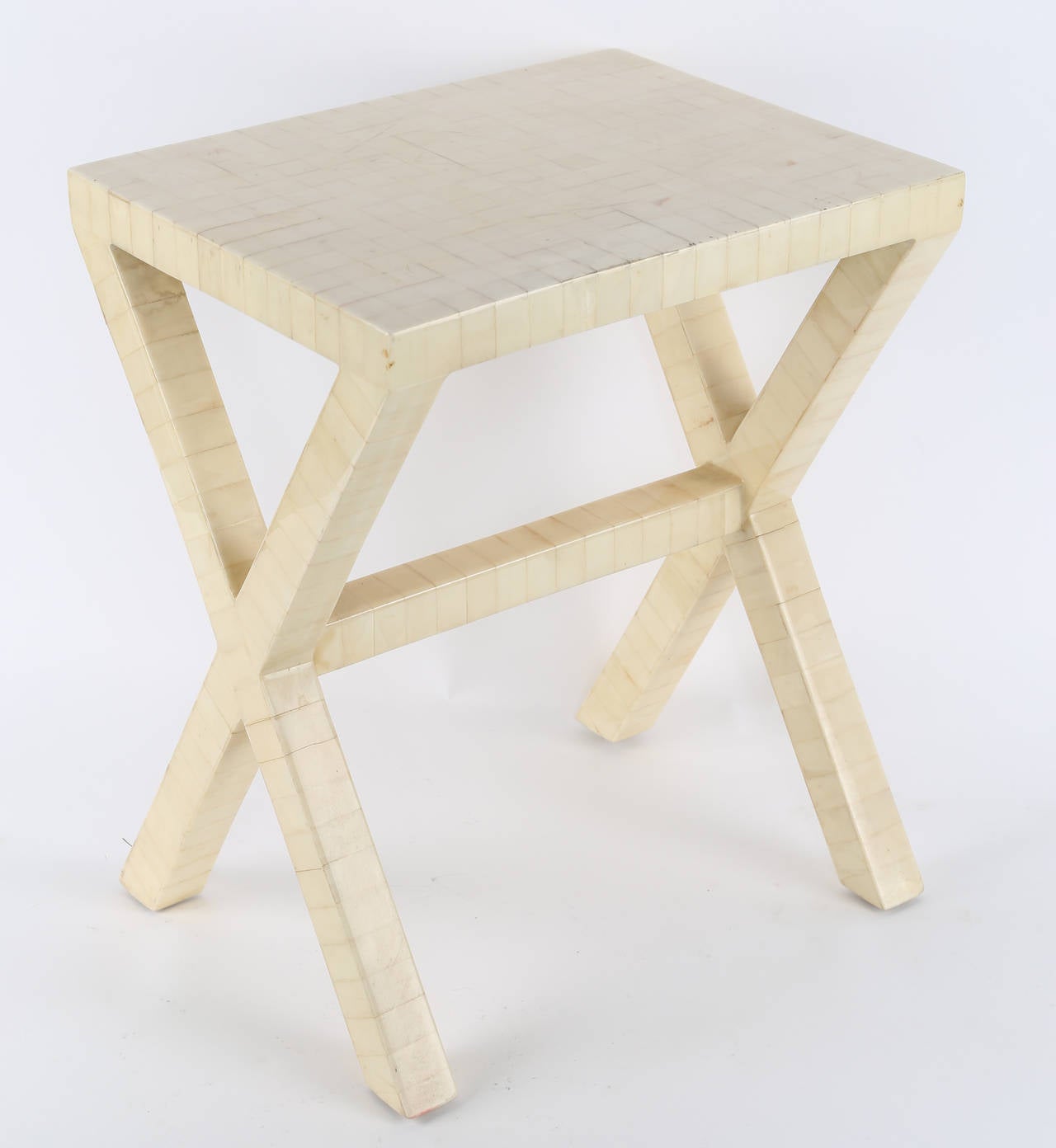 Diminutive and chic X-base occasional table clad in lacquered bone tiles. 

