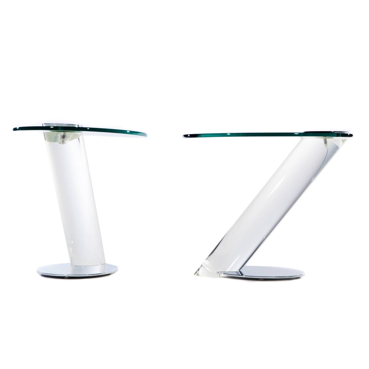 Super chic pair of cantilevered Lucite, chrome and glass side tables. The thick, angled Lucite column attaches to a chromed steel base and is topped by an oval glass top secured by an oval chrome plate. Signed Lion in Frost on base of each example.