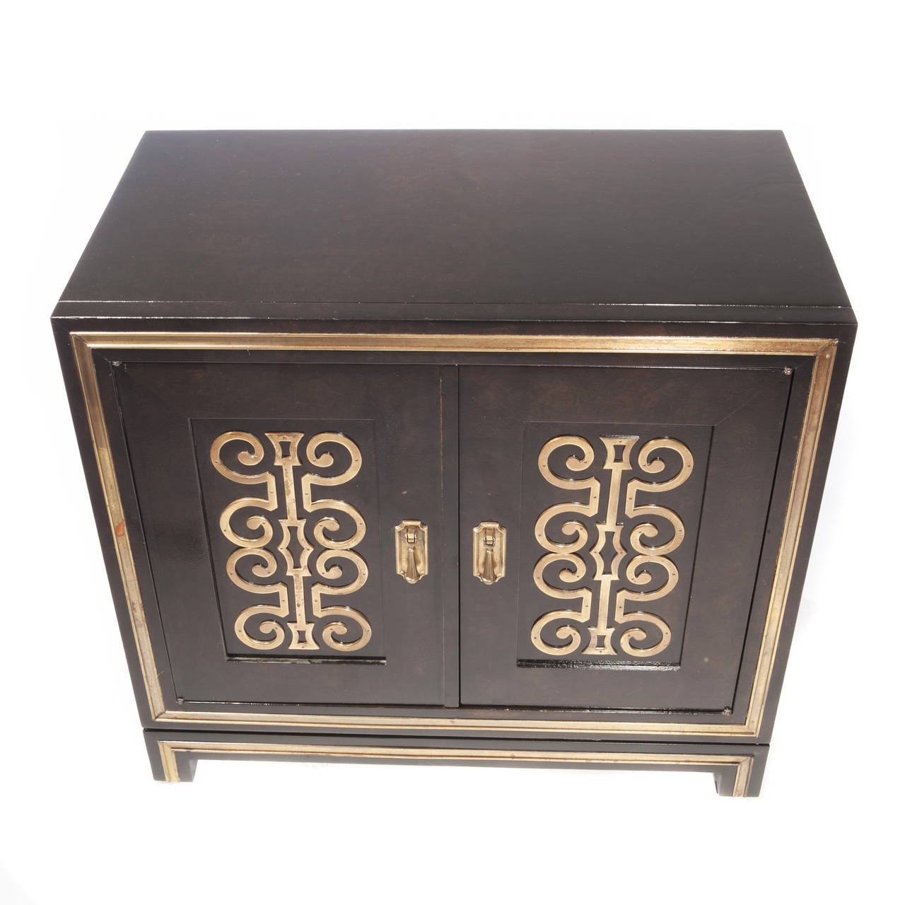 Swanky burl wood sideboard with brass trim and two doors with inset panels, each featuring decorative brass work, circa 1960s. The interior has one drawer and a single shelf. Mastercraft label to inside of drawer. 

See this item in our Brooklyn