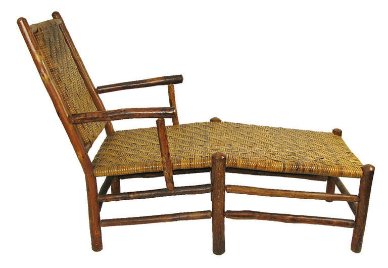 A rare piece of vintage hickory rustic furniture with a long leg rest and a slightly inclined back rest that evokes the leisure lounging of passengers on the deck of a steamship. It is much sturdier than traditional steamer chairs, having a hickory