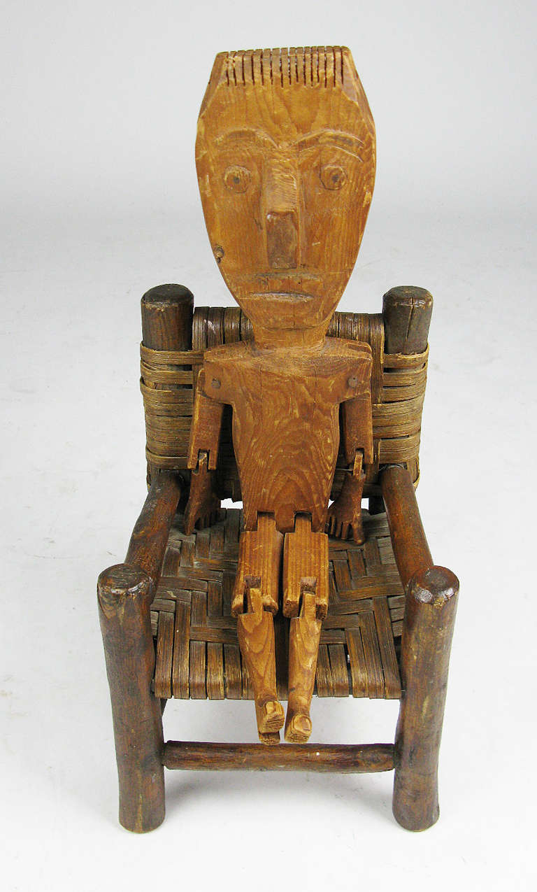 An amusing wooden Appalachian folk sculpture of an articulated man with a distinctively large head, strange thumbs, and a creatively sawn crew cut. The graining in the wood and the knot on the face also give him a lot of character. This includes a